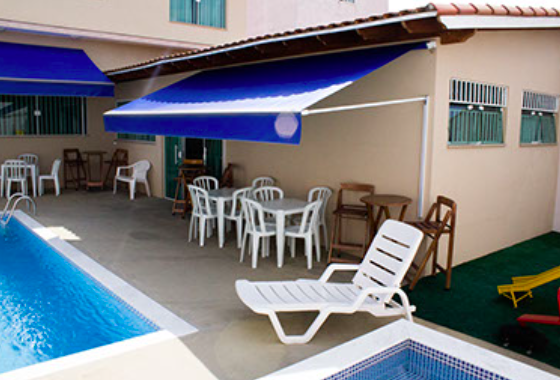 Área externa do Espaço Wannel com piscina, toldo e mesas
